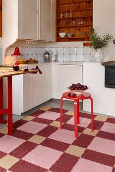 a kitchen with red and white checkered rugs on the floor next to an oven