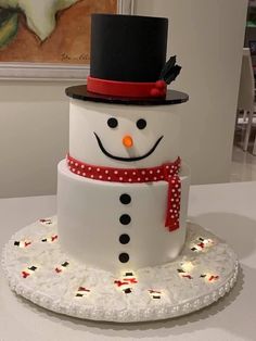 a snowman cake is sitting on a white plate with red and black polka dots