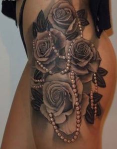 a woman's thigh with roses and pearls on it