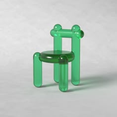 a green plastic chair sitting on top of a white floor next to a stool that is shaped like an animal