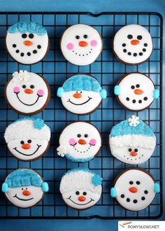 frosted cupcakes decorated with snowmen and hats on a wire cooling rack