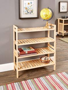 a wooden shelf sitting on top of a hard wood floor next to a painting and rug