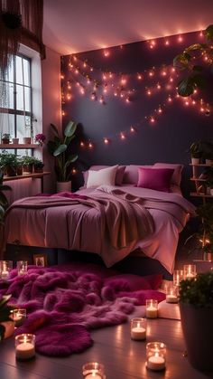 a bedroom with candles lit up and pink blankets on the bed, in front of a wall decorated with lights