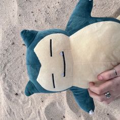 a person holding a stuffed animal in the sand