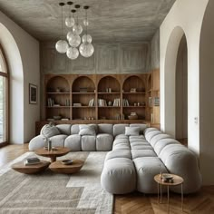 a large sectional couch sitting in a living room under a chandelier