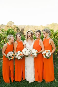 a group of women in orange dresses standing next to each other