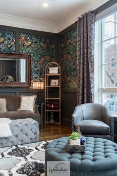 a living room filled with furniture next to a large window covered in floral wallpaper