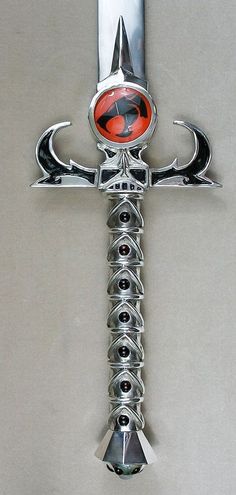 a cross made out of metal with an orange and black design on the center piece