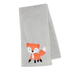 a gray towel with a fox embroidered on the front and back, sitting next to a white wall