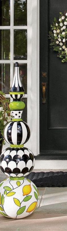 three vases sitting on the ground in front of a black door with white trim