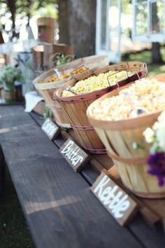 a wooden table topped with baskets filled with food next to a sign that says brit + co