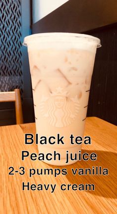 a cup of black tea peach juice on top of a wooden table