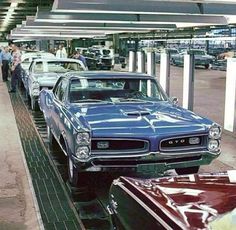 several classic muscle cars are on the assembly line