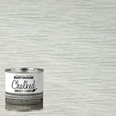 a can of white paint sitting on top of a wooden floor next to a wall