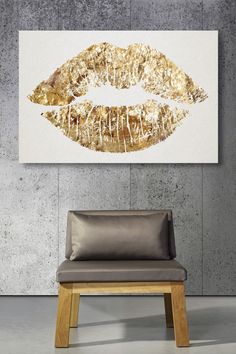 a gold lips painting on the wall above a chair