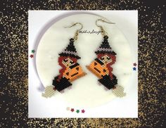 a pair of beaded pumpkins are hanging from earrings