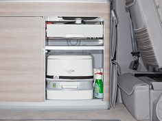 the interior of an airplane with two coolers and drinks in it's compartment