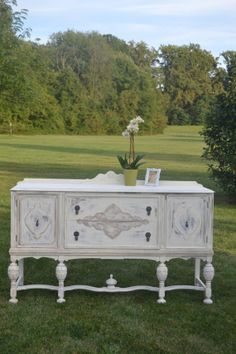 an old dresser is painted white and has flowers in it