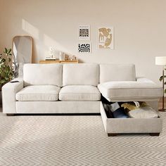 a living room with a couch, ottoman and mirror on the wall next to it