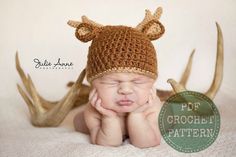 a baby wearing a knitted hat with antlers on it