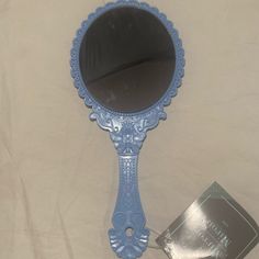 a blue mirror sitting on top of a bed next to a tag with a name tag