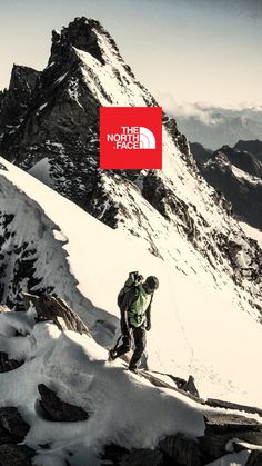 a man standing on top of a snow covered mountain next to a red sign that says the north face