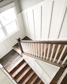 an overhead view of a wooden staircase with white painted walls