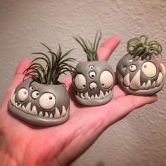 three little monster planters sitting in the palm of someone's hand