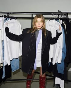 a woman standing in front of a rack of clothes