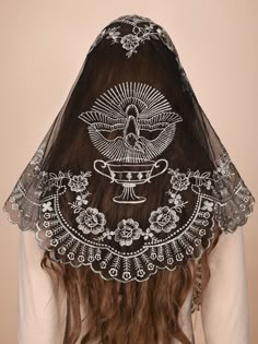 the back of a woman's head wearing a veil with an intricate design on it