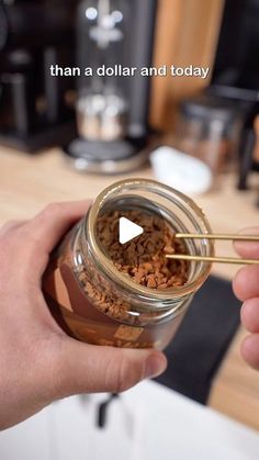 a person holding a glass jar filled with food