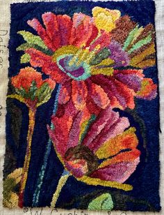 a close up of an embroidered piece of art with flowers on it's side