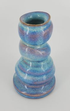 a blue vase sitting on top of a white table