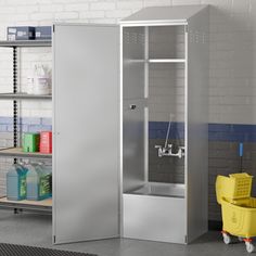 a large metal enclosure in the middle of a room with shelves and cleaning supplies on it