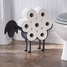 several rolls of toilet paper stacked on top of each other in front of a toilet