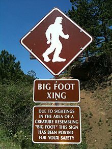 a bigfoot crossing sign on the side of a road