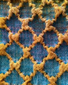 an image of a blue and yellow blanket with gold stars on the top, as if it were crocheted