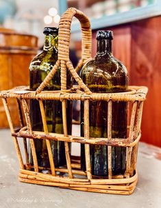 three bottles in a basket sitting on top of a table