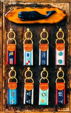 a bunch of key chains hanging on a wooden board with a pair of pliers