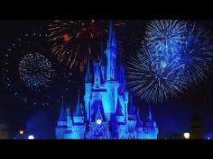 the castle is lit up with blue lights and fireworks