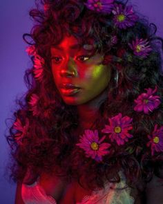 a woman with long curly hair and flowers on her head is posing for the camera