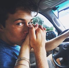 a man sitting in the driver's seat of a car with his hands on his face