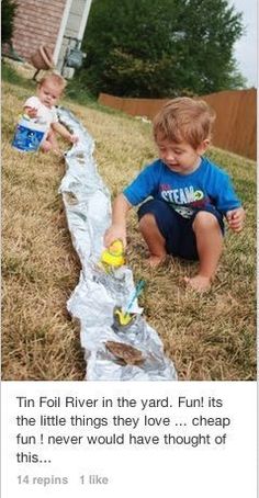 two toddlers playing with tin foil in the yard, one is trying to find something