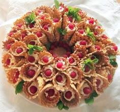 a cake that is on top of a white table cloth and has raspberries in it