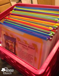 a pink bin filled with lots of colored pencils