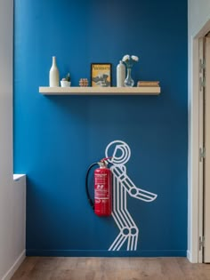 a fire extinguisher painted on the wall in a room with blue walls