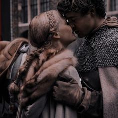 a man and woman are kissing in front of a red sign with the words game of thrones written on it