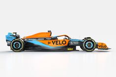 an orange and blue race car on a white background with the word velo written below it