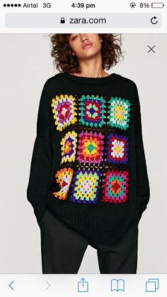 a woman wearing a black sweater with multicolored squares on it