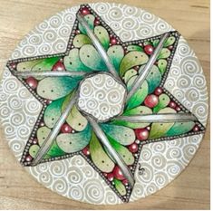 an artistically painted plate with a star on the center and berries in the middle